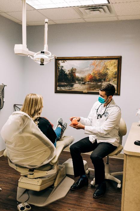 Dr. Nelson showing a patient dentures, winston salem nc