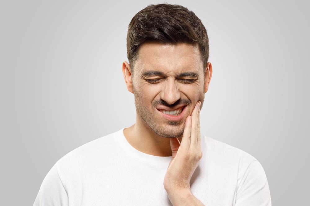 man in pain holding jaw | emergency dentist in winston salem