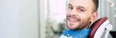 man smiling in dentist exam chair | winston salem dentistry