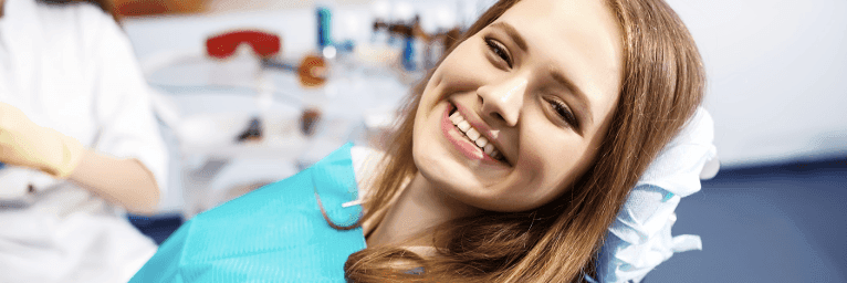 woman smiling in dentist exam chair | dentist winston salem nc