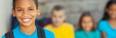 boy with backpack smiling | winston salem dentist