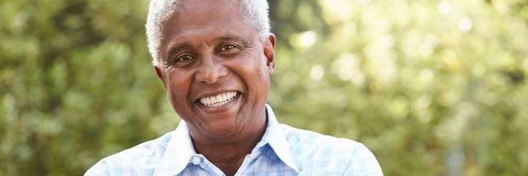 Black older man smiling after wisdom tooth removal, winston-salem nc