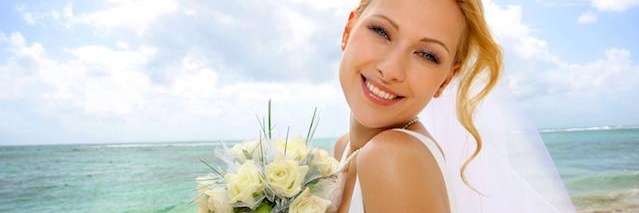 bride smiling on beach | cosmetic dentist winston salem