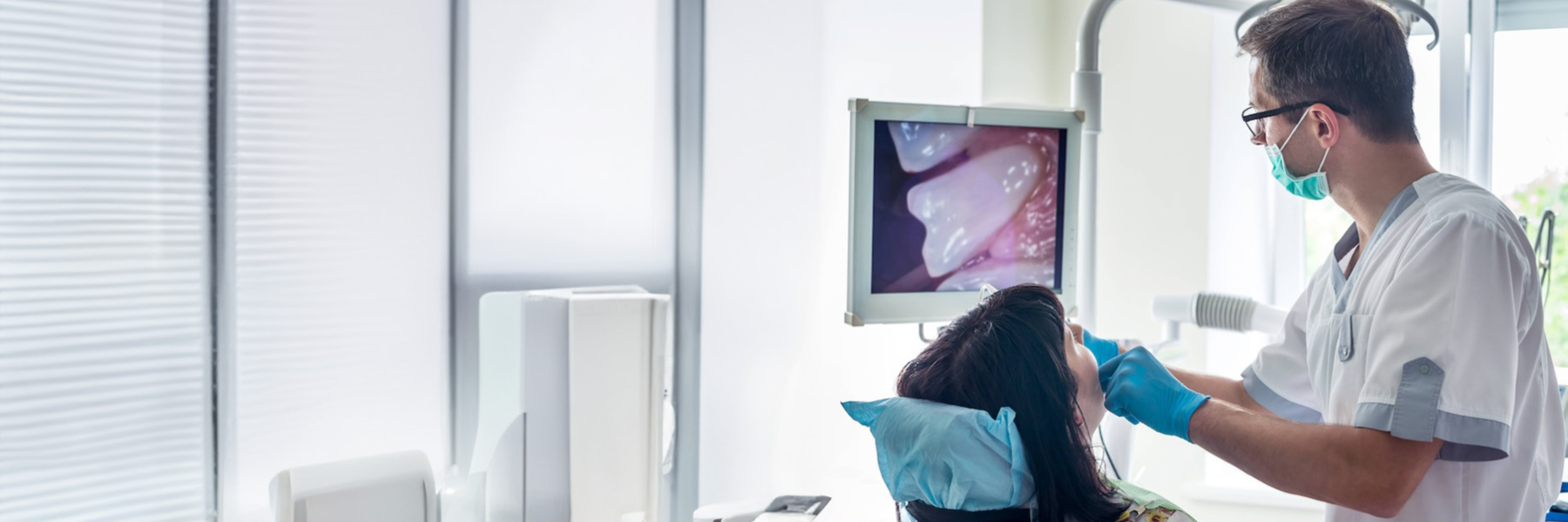 Dentist examining a patient using an intraoral camera during a weekend dental appointment