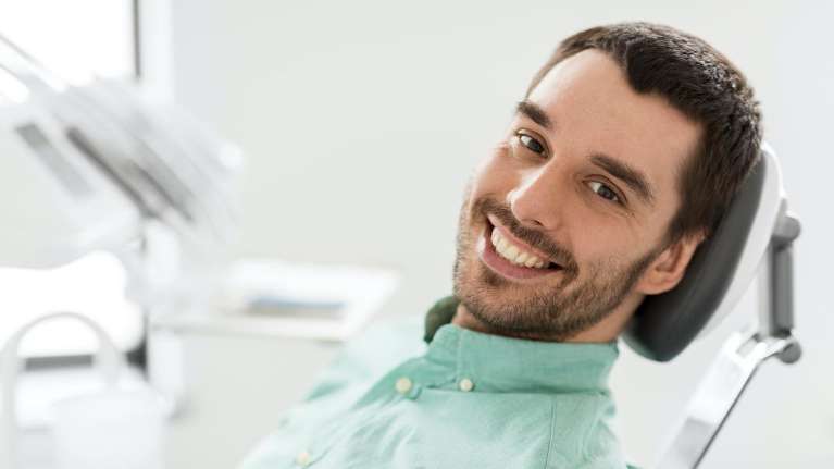 Man smiling in dental chair after sedation dentistry, winston-salem nc